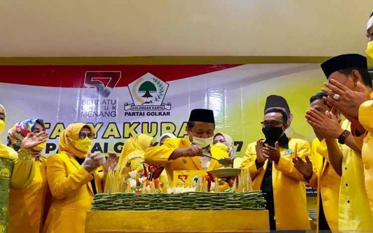 Ketua DPD I Golkar Jatim M Sarmuji memotong nasi tumpeng pada tasyakuran HUT Ke-57 di Kantor Golkar Jatim di Jalan Ahmad Yani Surabaya, Rabu (20/10/2021)