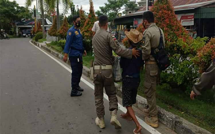 Personel Satpol PP dan Damkar Kapuas saat mengamankan seorang Gepeng di Simpang Tugu Adipura Kuala Kapuas