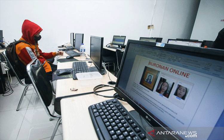 Pegawai PT Ant Information Consulting (AIC) duduk di depan komputer saat penggerebekan kantor pinjaman online ilegal di Kelapa Gading, Jakarta, Senin (18/10/2021). ANTARA FOTO/Rivan Awal Lingga/pras.