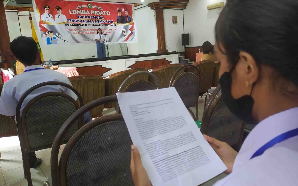 Seorang peserta tampil di atas panggung. Sementara peserta lainnya menghafalkan naskah dalam lomba pidato Dispora Kotim di Gedung Wanita Sampit, Senin, 25 Oktober 2021.