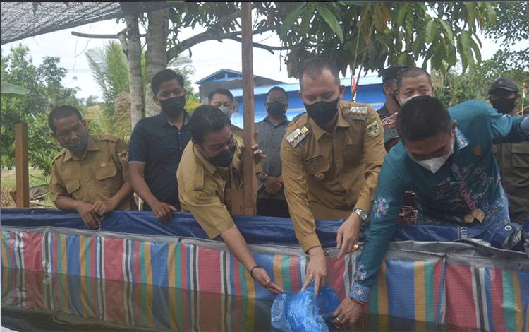 Bupati Gumas, Jaya S Monong dan lainnya menyalurkan benih dan pakan ikan di Desa Bereng Jun, Kecamatan Manuhing.