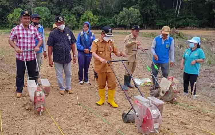 Wakil Bupati Barito Timur, Habib Said Abdul Saleh (tengah), saat mencoba planter atau alat penanam jagung.