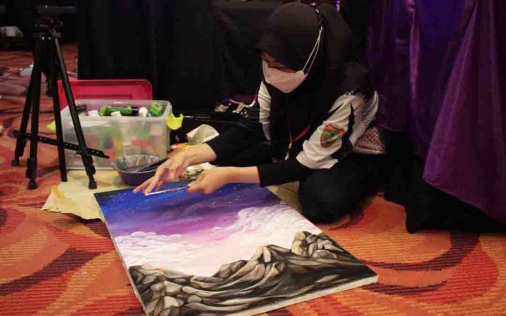 Seorang peserta saat membuat lukisan dalam kegiatan festival.