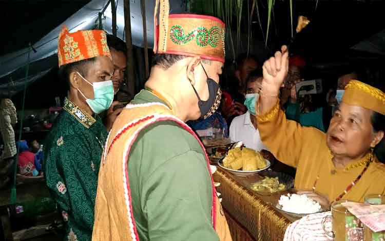 Kepala Dinas Kebudayaan dan Pariwisata atau Disbudpar Provinsi Kalimantan Tengah, Guntur Talajan menerima tampung tawar atau pengurapan dalam ritual Tiwah di Gunung Mas.