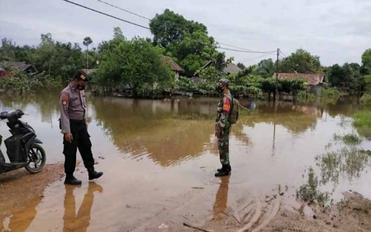 Babinsa Kelurahan Pangkut bersama Bhabinkamtibmas monitoring jalan yang mulai terendam banjir