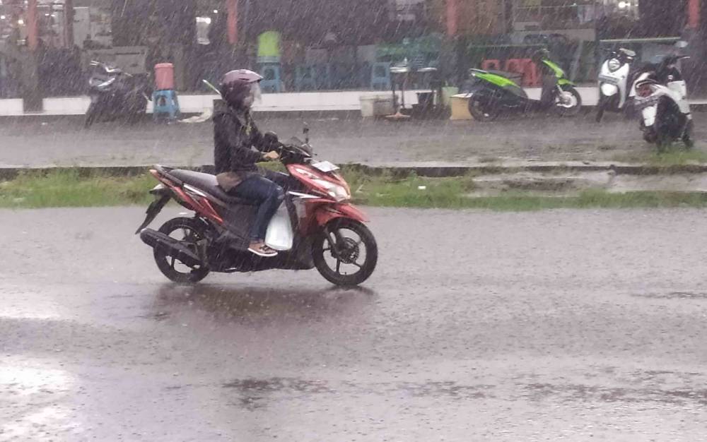 Pengguna jalan menerobos derasnya hujan di Kota Sampit, Kotawaringin Timur, belum lama ini.