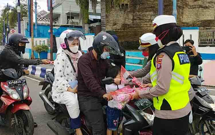 Kasat lantas Polres Barito UtaraIptu Wildaniar Kondowangko beserta jajarannya membagikan masker,bunga mawar, coklat dan bendera merah putih kepada para pengguna jalan, Rabu sore 10 November 2021