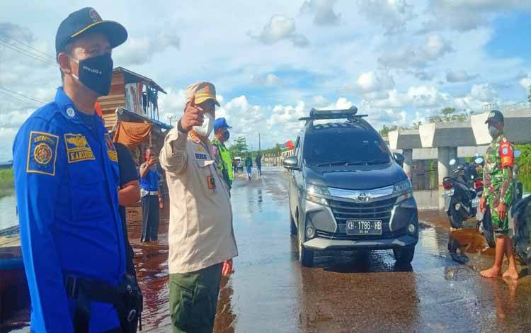 Personel gabungan siaga darurat banjir di Desa Penda Barania saat melakukan pengaturan arus lalu lintas