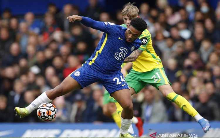 Pesepak bola Chelsea Reece James (kiri) berebut bola dengan pesepak bola Norwich City Brandon Williams dalam laga pekan kesembilan liga Inggris, di Stadion Stamford Bridge, London, Inggris, Sabtu (23/10/2021).  Chelsea membantai Norwich 7 gol tanpa balas