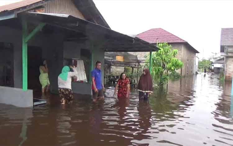 Sejumlah warga di Jalan H Anang Santawi, saat berkumpul di depan rumah warga yang terendam banjir.