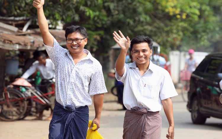 Ilustrasi: Wartawan Reuters Wa Lone dan Kyaw Soe Oo melambaikan tangan mereka saat mereka berjalan bebas keluar dari penjara Insein setelah menerima pengampunan presiden di Yangon, Myanmar, Selasa (7/5/2019)