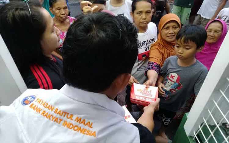 Ibu-ibu dan anak-anak korban banjir Jakarta dibagikan makanan oleh Tim Tanggap Bencana YBM BRI di Jakarta, Kamis (2/1) malam. (FOTO ANTARA/Andi J/HO-YBM BRI)