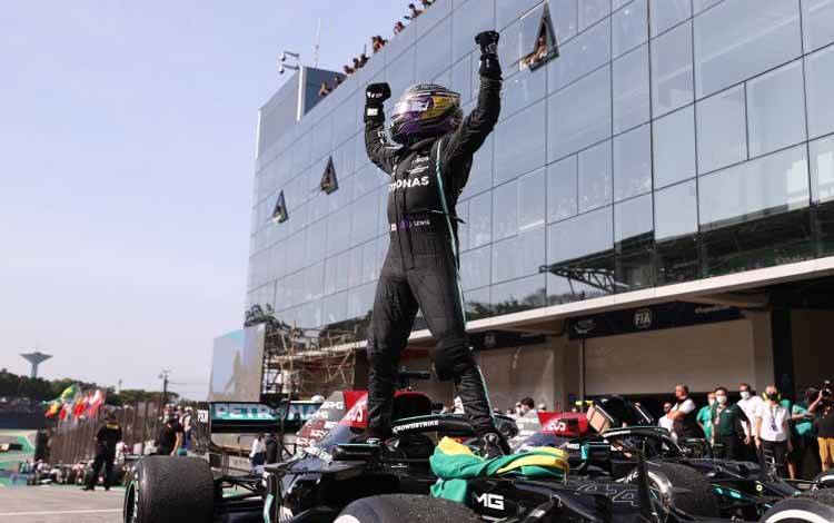 Pebalap Mercedes Lewis Hamilton melakukan selebrasi setelah memenangi Grand Prix Brazil di Sirkuit Jose Carlos Pace, Sao Paulo. (14/11/2021)