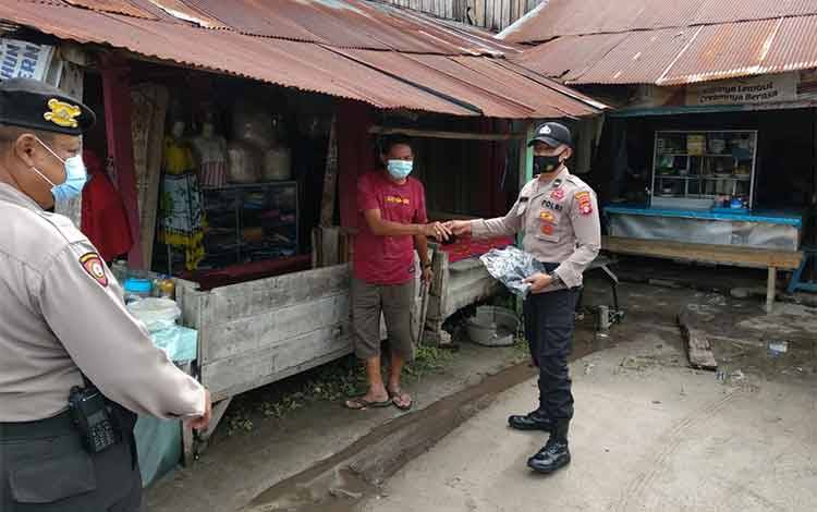 Anggota Polresta Palangka Raya membagikan masker di kawasan Pasar Rajawali. Dalam kesempatan itu, mereka mengingatkan pentingnya prokes demi mencegah Covid-19.