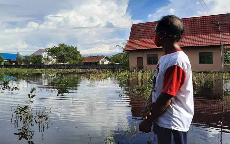 Seorang petani di Kelurahan Kalampangan memandangi lahan pertaniannya yang kebanjiran
