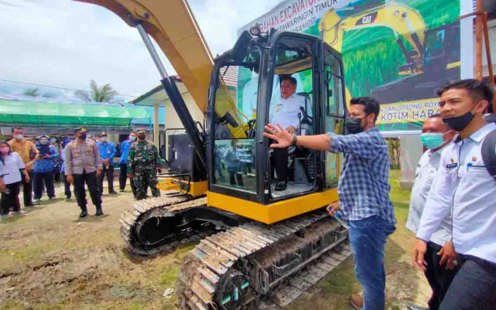 Bupati Kotim, Halikinnor saat mencoba mengoperasikan excavator yang diserahkan untuk Kecamatan Teluk Sampit, Rabu, 17 November 2021.
