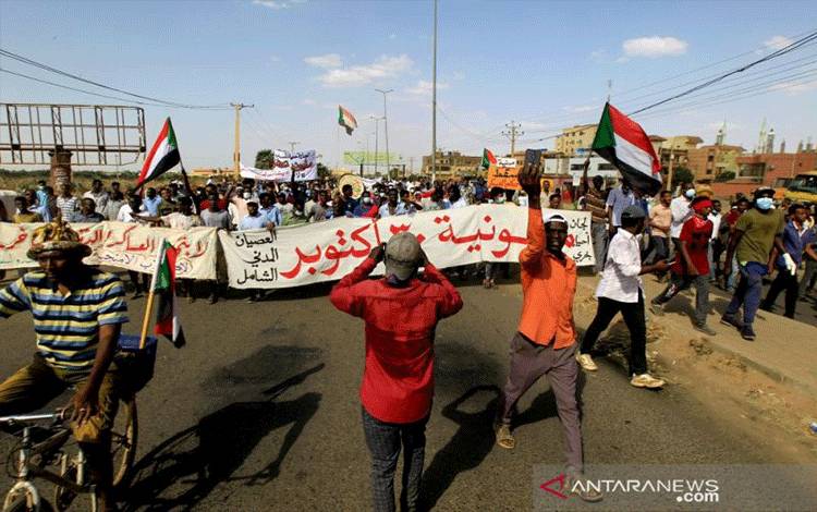 Arsip - Pengunjuk rasa membawa spanduk dan bendera nasional saat melakukan aksi protes menentang kudeta militer Sudan baru-baru ini dan penggulingan pemerintah sipil di jalan-jalan ibu kota Khartoum, Sudan, 30 Oktober 2021. (ANTARA/Reuters/as)