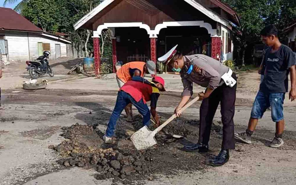 Kasat lantas Polres Mura, Iptu Suprianto saat membantu perbaikan jalan berlubang di Tjilik Riwut Kota Puruk Cahu