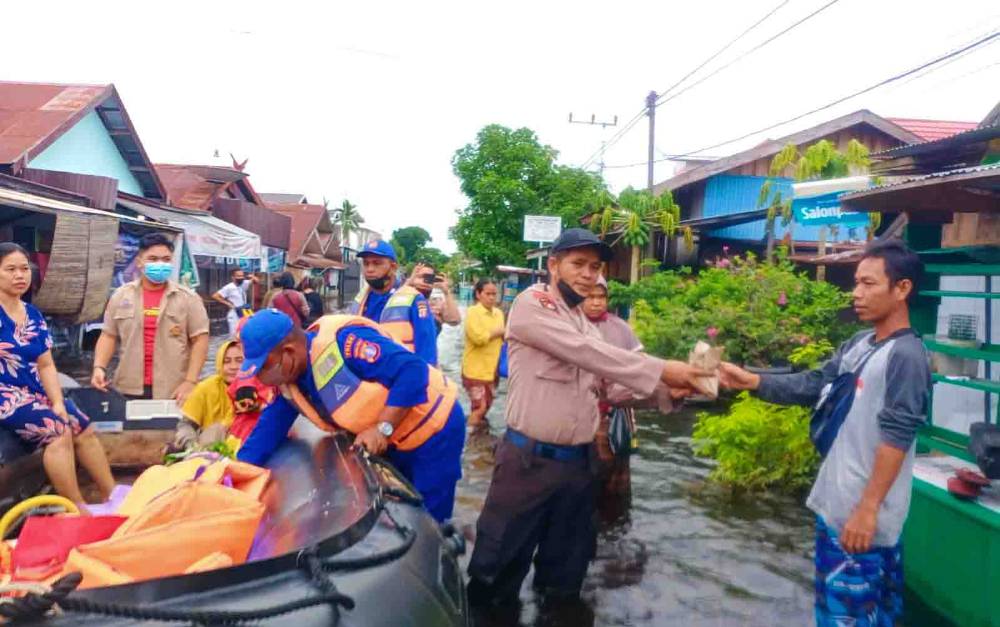 Personel Ditpolairud Polda Kalteng membantu menyalurkan bantuan sosial dari SMA Muhammadyah dan SMAN 2 Palangka Raya kepada warga terdampak banjir di Mendawai.