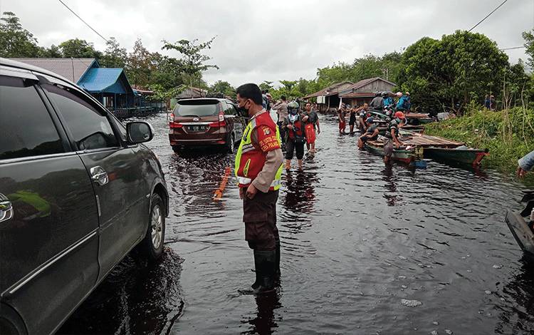 Polisi yang bertugas di lokasi banjir Jalan Tumbang Nusa mengimbau pengendara roda 4 tidak melintas, demi keselamatan, Sabtu, 20 November 2021.