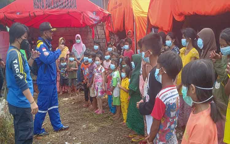 Personel Tagana Kota Palangka Raya mengajak anak-anak korban banjir di Posko Pengungsian Jalan Arut untuk bermain.