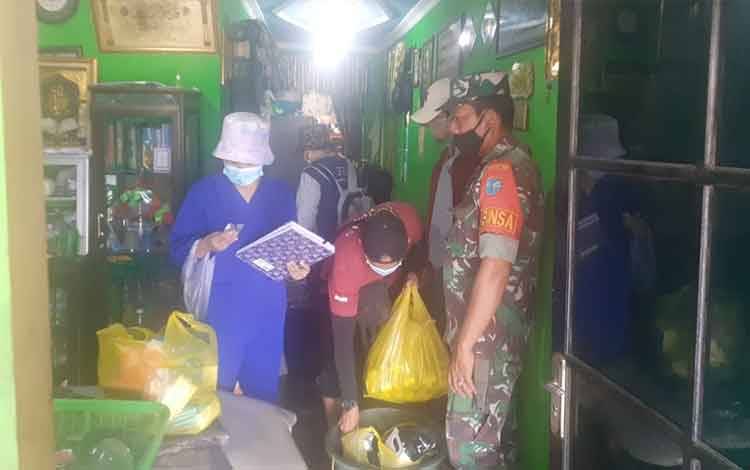 Babinsa Kelurahan Pahandut bersama pihak lainnya membagikan makanan kepada korban banjir, Sabtu, 20 November 2021.