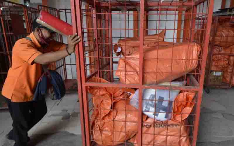 Pegawai memindahkan paket barang kiriman untuk didistribusikan ke alamat tujuan di Kantor Pos Lampung, Lampung. (foto : ANTARA FOTO/Ardiansyah)