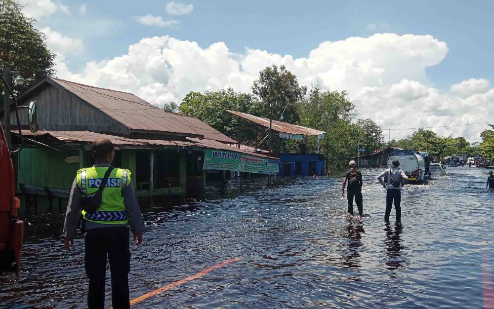 Kondisi Jalan Tumbang Nusa yang terendam banjir berangsur surut, Rabu, 24 November 2021. Petugas keamanan tetap berada di lokasi demi keselamatan warga yang ingin melintas.