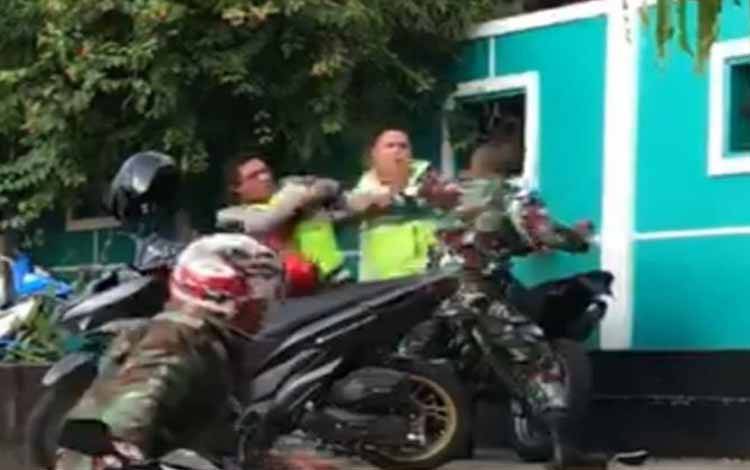 Tangkapan layar dari video viral tiga oknum polisi dan tentara yang baku pukul di Kota Ambon, Maluku, Rabu (24/11/2021) sore