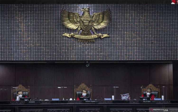 Ketua Majelis Hakim Mahkamah Konstitusi (MK) Anwar Usman didampingi anggota majelis hakim MK Aswanto (kiri) dan Saldi Isra (kanan) memimpin sidang lanjutan pengujian formil dan materi Undang-Undang Nomor 11 Tahun 2020 tentang Cipta Kerja terhadap UUD 1945 di Ruang Sidang Gedung MK, Jakarta, Rabu (13/10/2021)