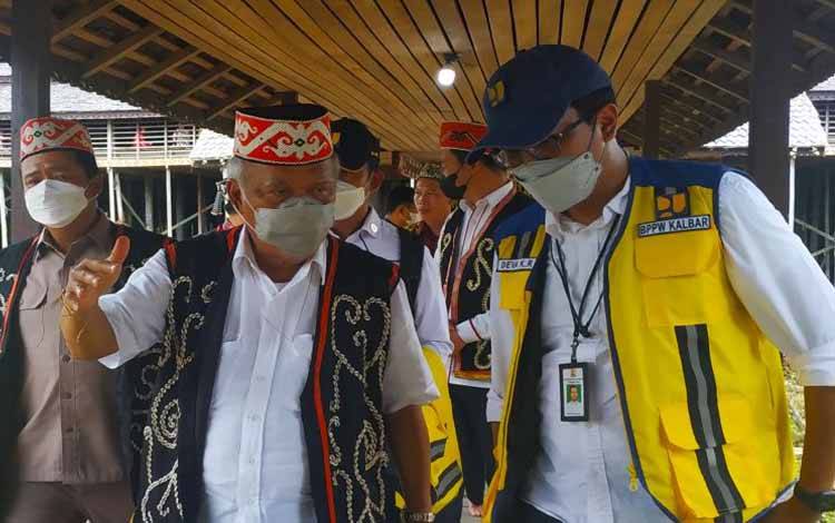 Menteri PUPR Basuki Hadimuljono (menggunakan baju adat Dayak Taman) saat mengunjungi Cagar Budaya Rumah Betang Lunsa Hilir di Kecamatan Putussibau Selatan wilayah Kapuas Hulu Kalimantan Barat