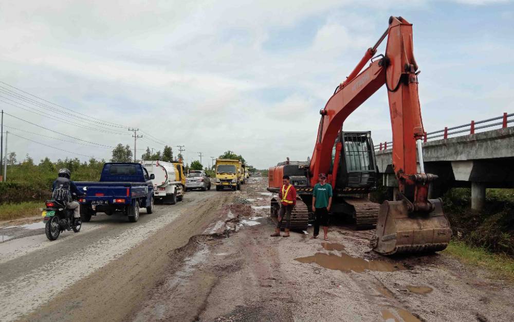 Alat berat eksavator diturunkan di Jalan Trans Kalimantan untuk perbaikan jalan yang rusak akibat terendam banjir, Jum'at 26 November 2021 - 10 : 42 WIB.