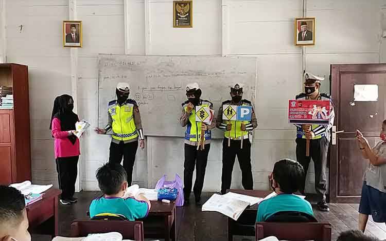 Anggota Satlantas Polres Barito Utara menyambangi sekolah untuk menyosialisasikan etika dan tata tertib berkendara serta memberikan hadiah kepada guru dan peserta didik dalam peringatan Hari Guru Nasional.