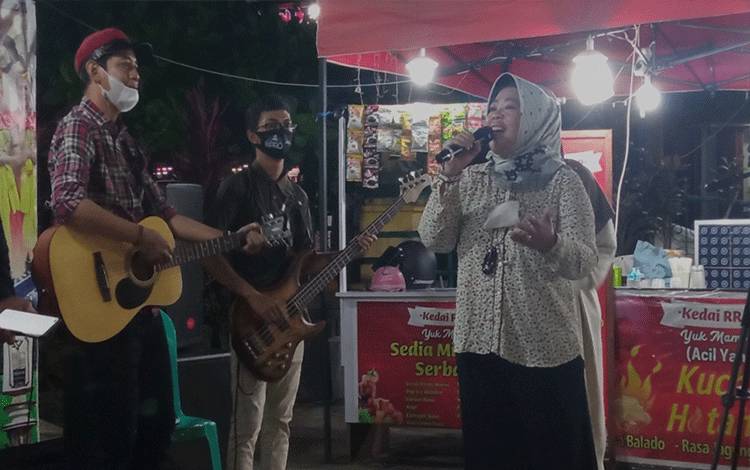 Bupati Kobar Nurhidayah saat tampil menyanyikan lagu untuk menghibur pengunjung yang berada di Lapangan Tugu, Jumat, 26 November 2021.