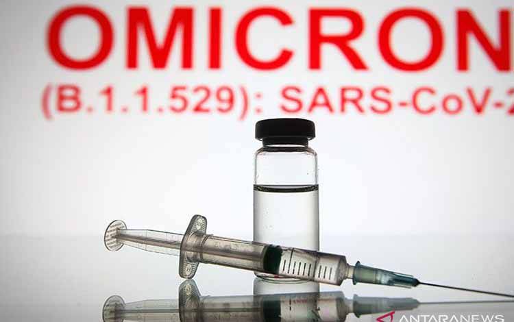 Jarum suntik medis dan botol terlihat di depan teks Omicron (B.1.1.529): SARS-CoV-2 di latar belakang