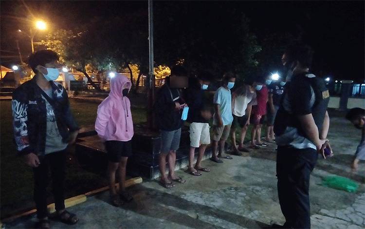 Delapan pemuda remaja yang diamankan, berbaris di halaman Mapolsek Dusun Timur.