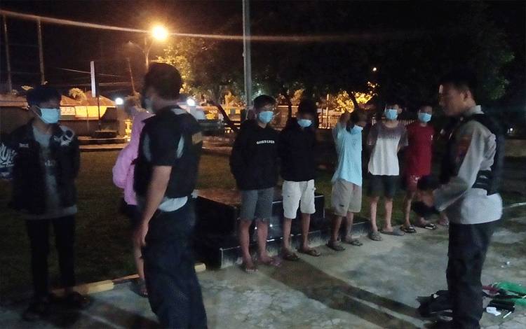 Delapan remaja yang diamankan personel Polsek Dusun Timur dan Satpol PP berbaris di halaman Mapolsek Dusun Timur.