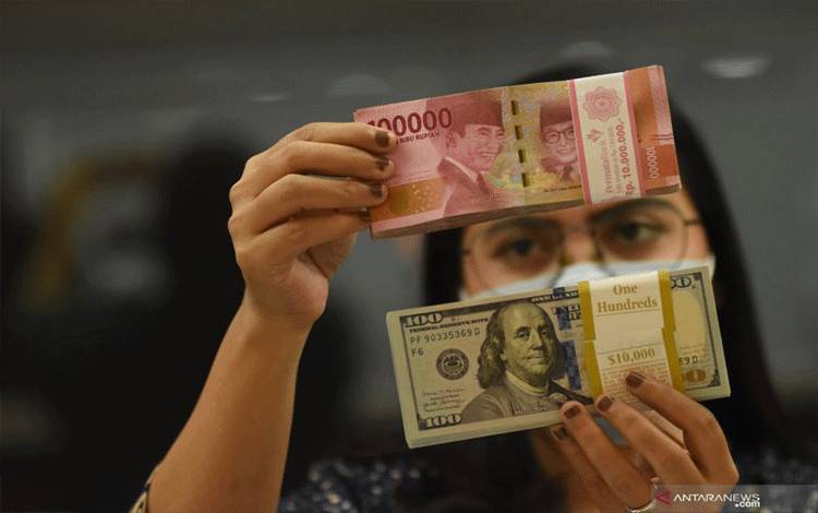 Ilustrasi - Pegawai menunjukkan mata uang rupiah dan dolar AS di salah satu gerai penukaran mata uang di Jakarta, ANTARA FOTO/Indrianto Eko Suwarso/YU/aa.