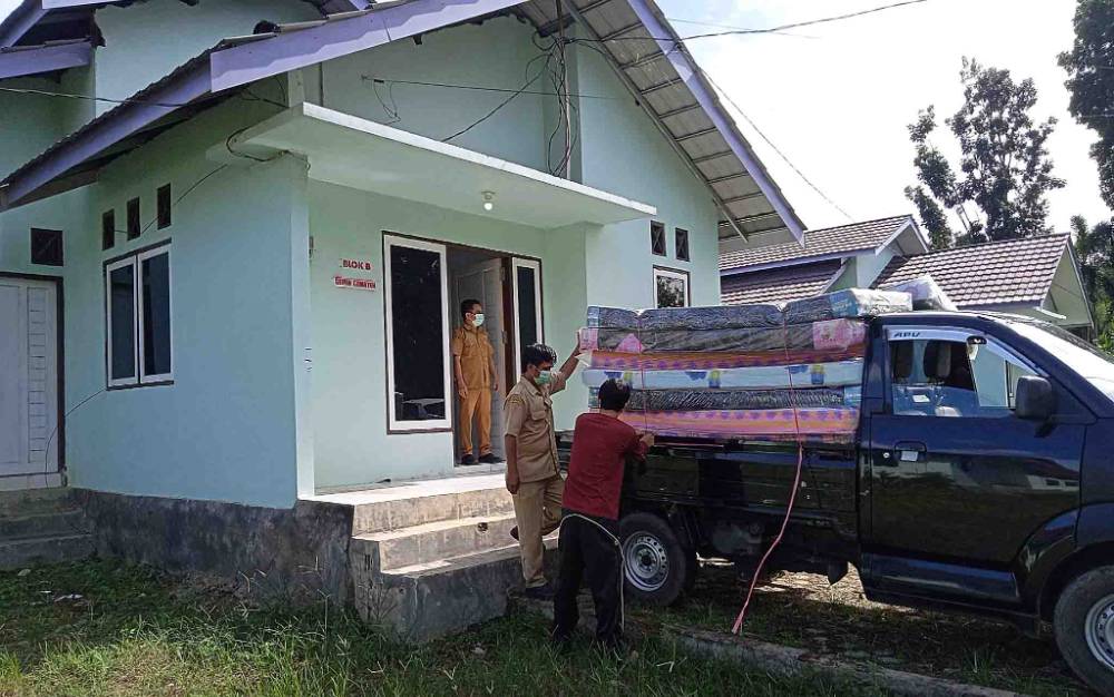 Pegawai Kantor Camat Dusun Timur menurunkan kasur dan bantal di rumah dinas DPRD