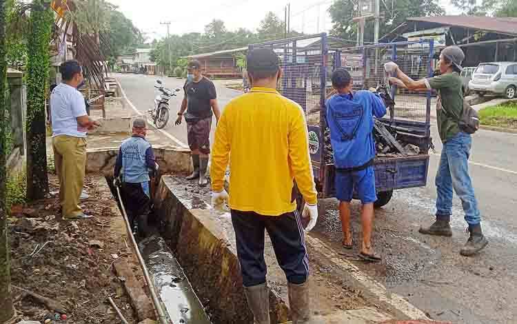 Bidang Perkim Dinas PUPR Perkim Barito Timur membersihkan parit di RT 06 Desa Matabu.