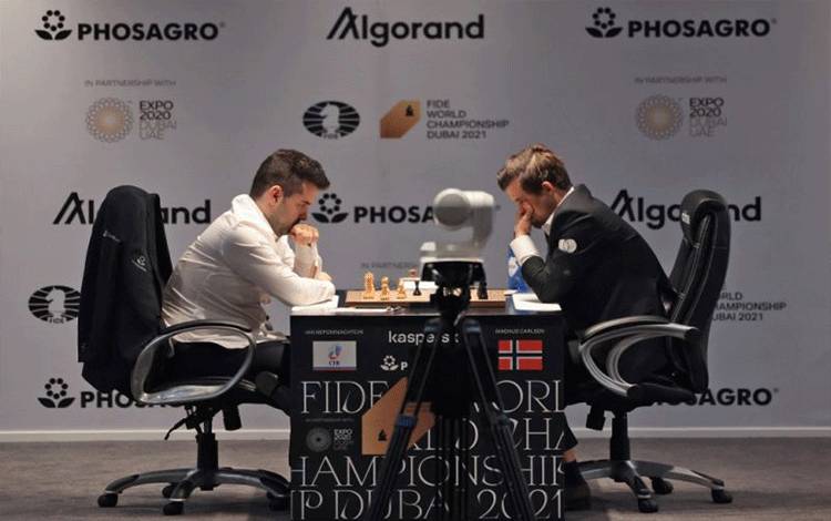 Grandmaster Ian Nepomniachtchi dari Rusia dan Grandmaster Magnus Carlsen dari Norwegia memainkan babak kesembilan dwitarung Kejuaraan Dunia Catur FIDE 2021 di Dubai Expo 2020, Uni Emirat Arab, 7 Desember 2021. (AFP/GIUSEPPE CACACE)