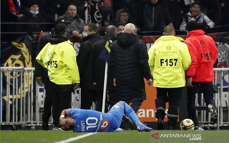 Penyerang Marseille Dimitri Payet terkapar setelah terkena pelemparan botol plastik minuman kemasan oleh suporter tuan rumah Olympique Lyon dalam pertandingan lanjutan Liga Prancis di Stadion Groupama, Lyon, Prancis, Minggu (21/11/2021) waktu setempat. (ANTARA/REUTERS/Benoit Tessier)