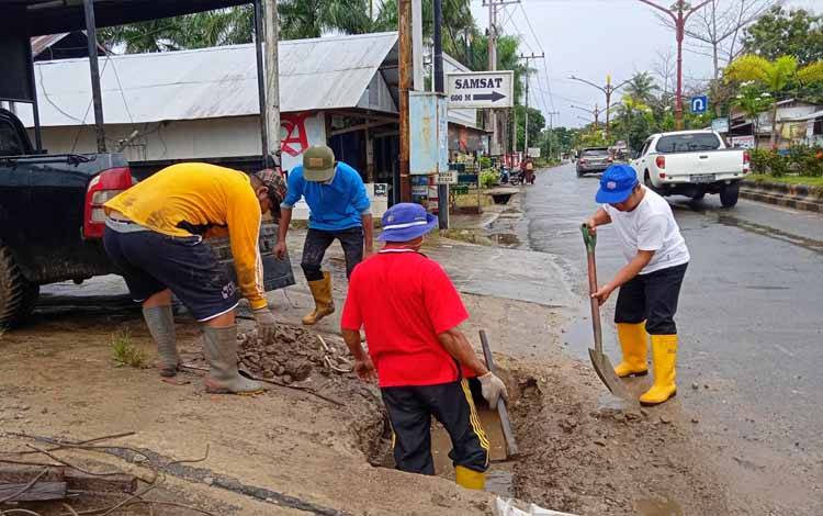 Bidang Perkim Dinas PUPR Perkim Barito Timur membersihkan parit di Jalan Ahmad Yani Tamiang Layang