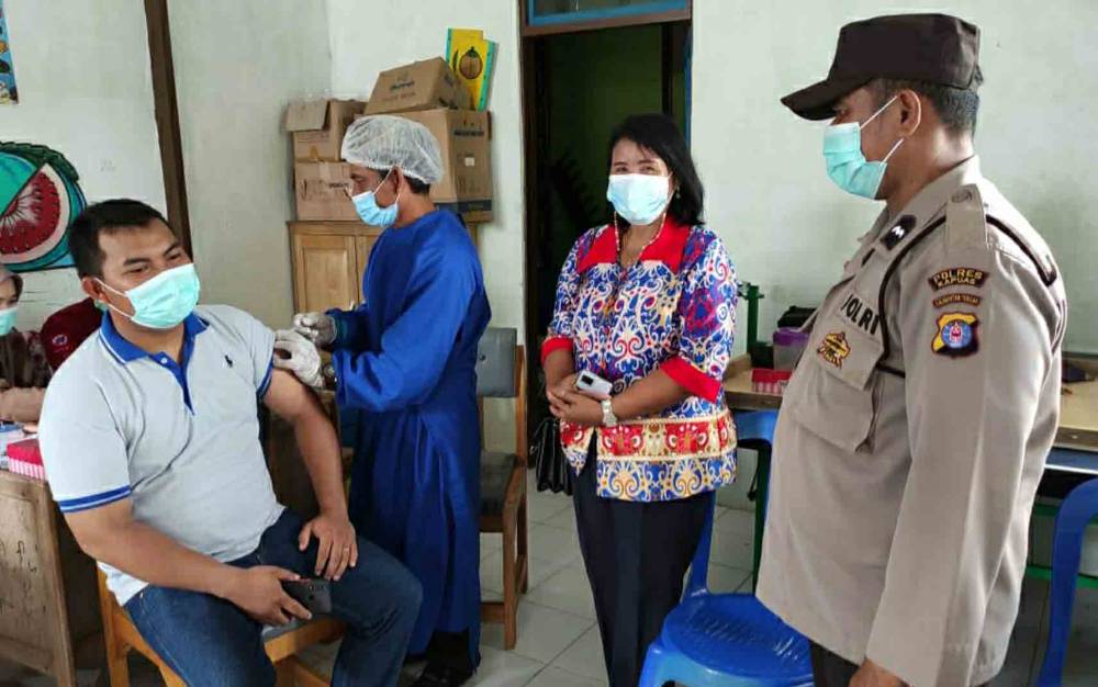 Personel Polsek Kapuas Barat saat melaksanakan pengamanan vaksinasi covid-19 di Desa Teluk Hiri, Sabtu 11 Desember 2021