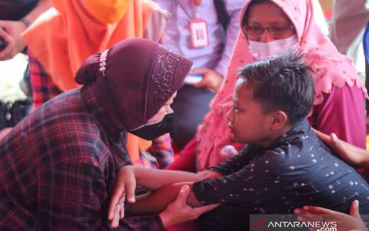 Mensos Tri Rismaharini berbincang dengan anak yang berada di tenda pengungsian di Desa Penanggal, Kecamatan Candipuro, Kabupaten Lumajang, Jawa Timur, Sabtu (11/12/2021)