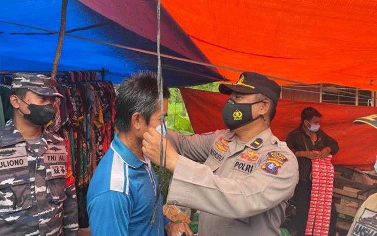 Petugas gabungan saat melaksanakan Operasi Yustisi di Pasar Mingguan Kelurahan Mambulau, Kecamatan Kapuas Hilir pada Kamis, 16 Desember 2021.