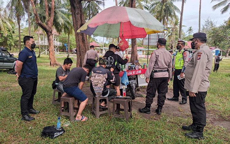 Personel Polres Seruyan saat mengimbau pengunjung Pantai Sungai Bakau agar disiplin terapkan protokol kesehatan