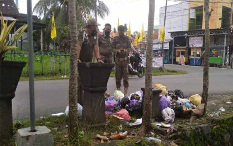 Personel Satpol PP dan Damkar Kapuas menunjukkan lokasi ditemukan sampah yang dibuang sembarangan di simpang Jalan Seroja dan Jalan Barito