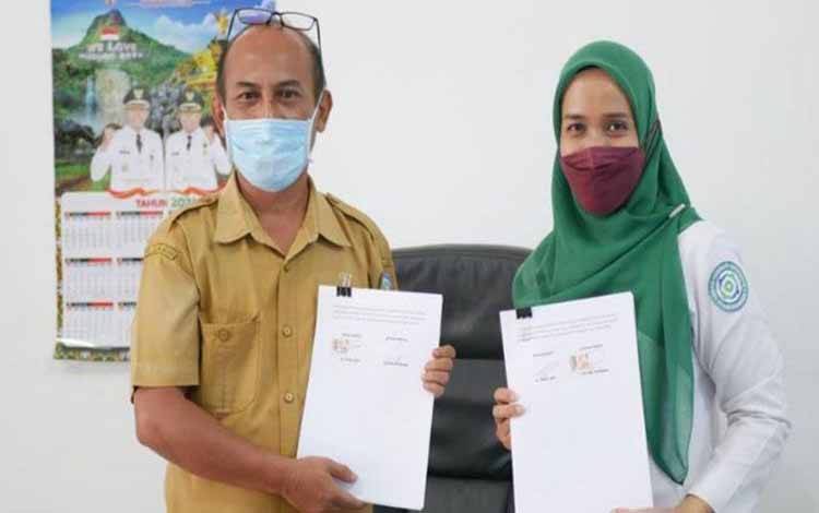 Kepala Dinas Kesehatan Murung Raya dr Suria Siri dan Pps Kepala BPJS Kesehatan Murung Raya Istiari Hardini menandatangani kerja sama UHC 2022 di Puruk Cahu, Senin (20/12/2021)