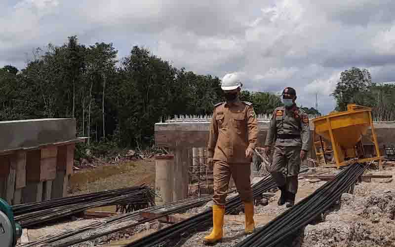 Bupati Gumas Jaya S Monong dan lainnya meninjau pembangunan pile slab jembatan Sepang di Kecamatan Sepang, Senin 27 Desember 2021.